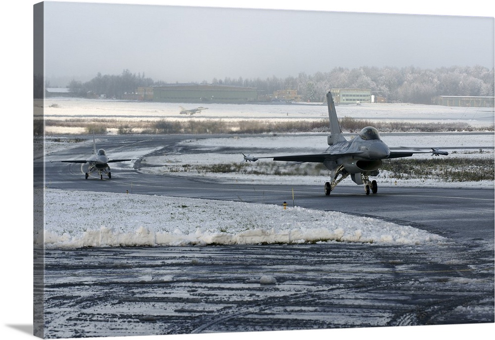 Two F-16 Fighting Falcons taxi down the runway in Florennes, Belgium.