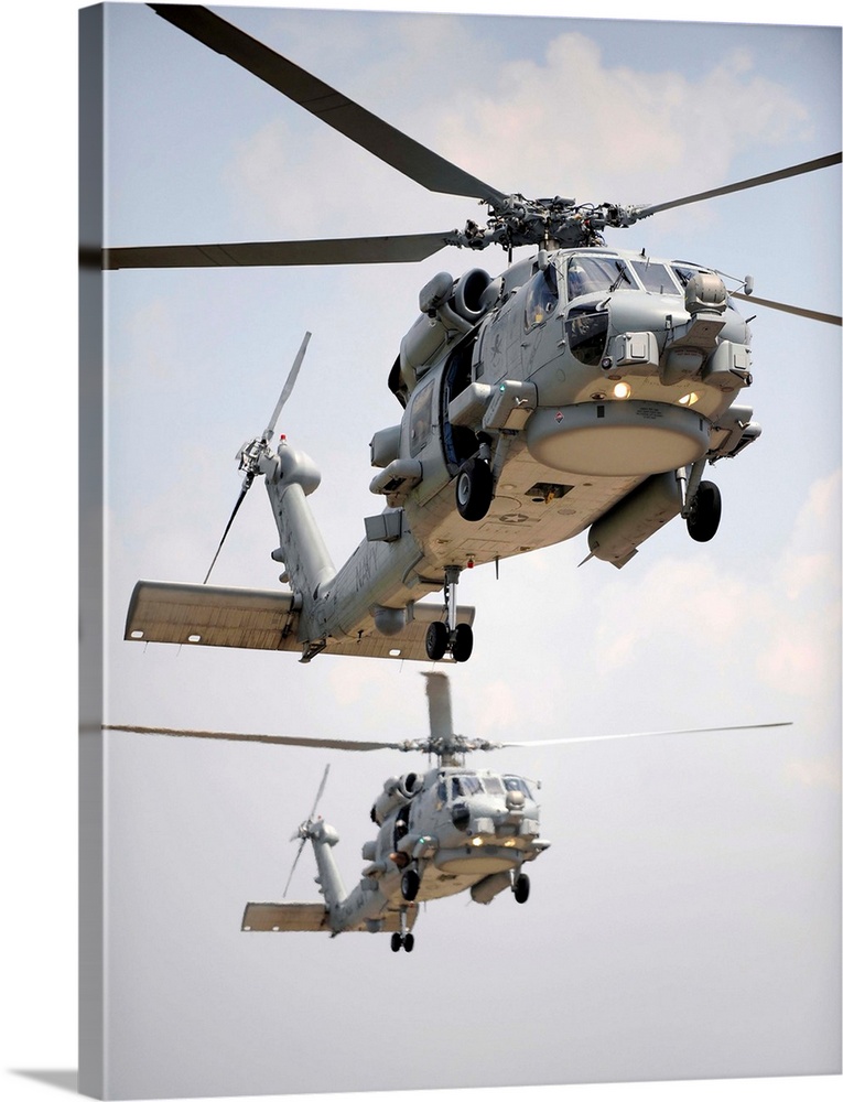 Two multi-mission MH-60R Sea Hawk helicopters fly in tandem.