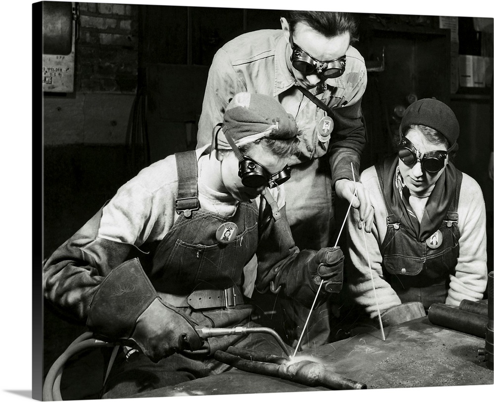 Two women learning to weld with their instructor, 1943.