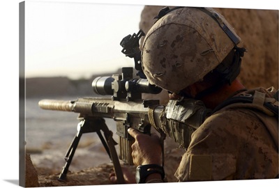 U.S. Marine looks through the scope of his M16A4 rifle for enemy forces