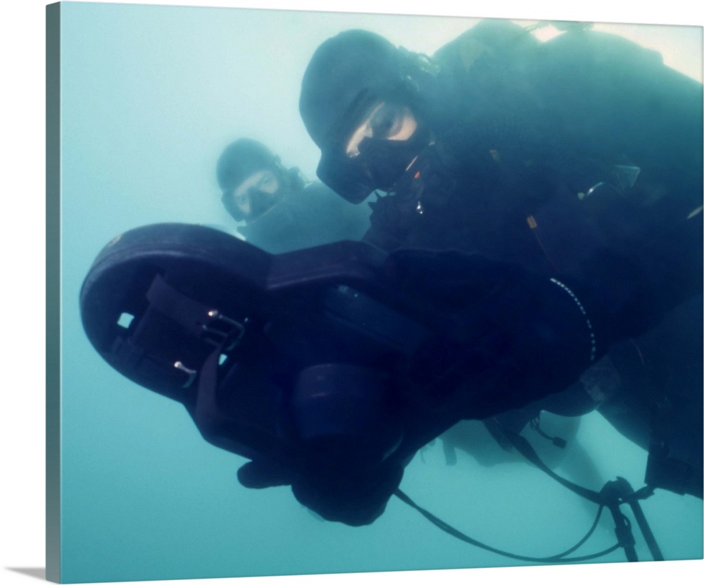 U.S. Navy SEAL combat swimmer pair diving LAR-V pure oxygen rebreather, navigate using a swimmer attack board to reach a t...