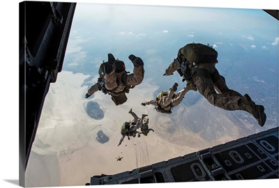 U.S. Pararescuemen and U.S. Marines jump from a HC-130 over Djibouti