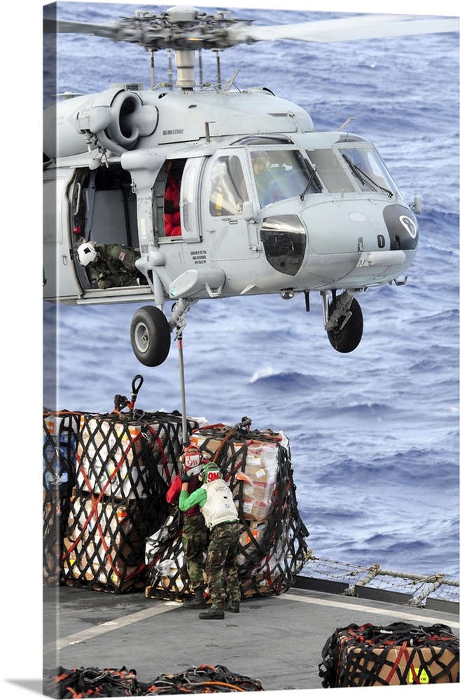 U.S. Sailors connect a cargo pendant to an MH-60S Seahawk helicopter.