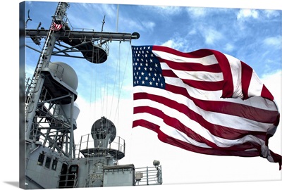 USS Cowpens flies a large American flag during a live fire weapons shoot