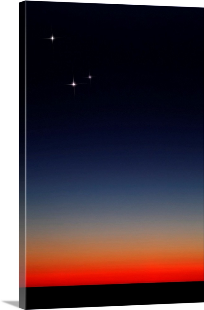 Venus, Mercury and Mars above the glowing horizon at dawn.