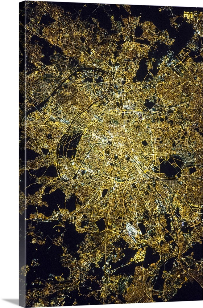 View from space of Paris, France, showing the pattern of the street grid and city lights at night.