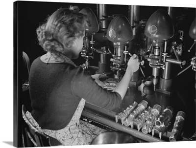 Woman worker drilling castings for toy locomotives in a factory plant