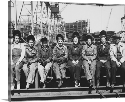 Women welders wearing protective clothing and seated outdoors