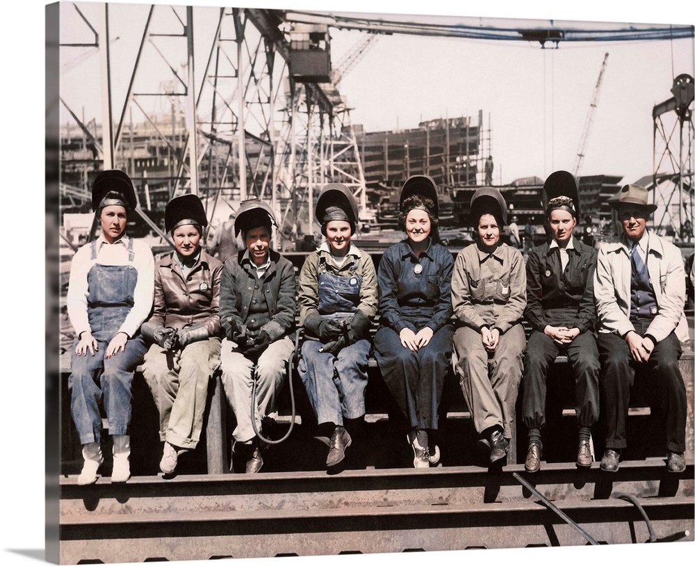 Women welders wearing protective clothing and seated outdoors.