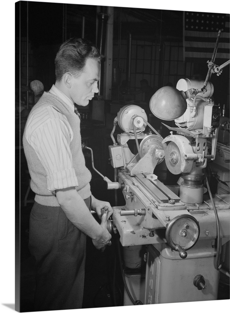 February 1942 - A skilled worker grinds permanent magnet rotors on a converted Norton cutter-grinder machine at a plant in...