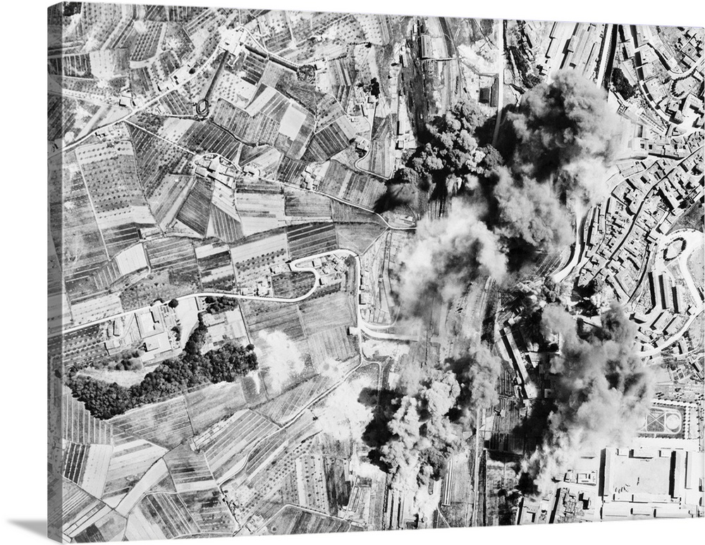 WWII photo of Axis railroad yards at Siena, Italy being aerial bombed by Mediterranean Allied Air Force bombers.