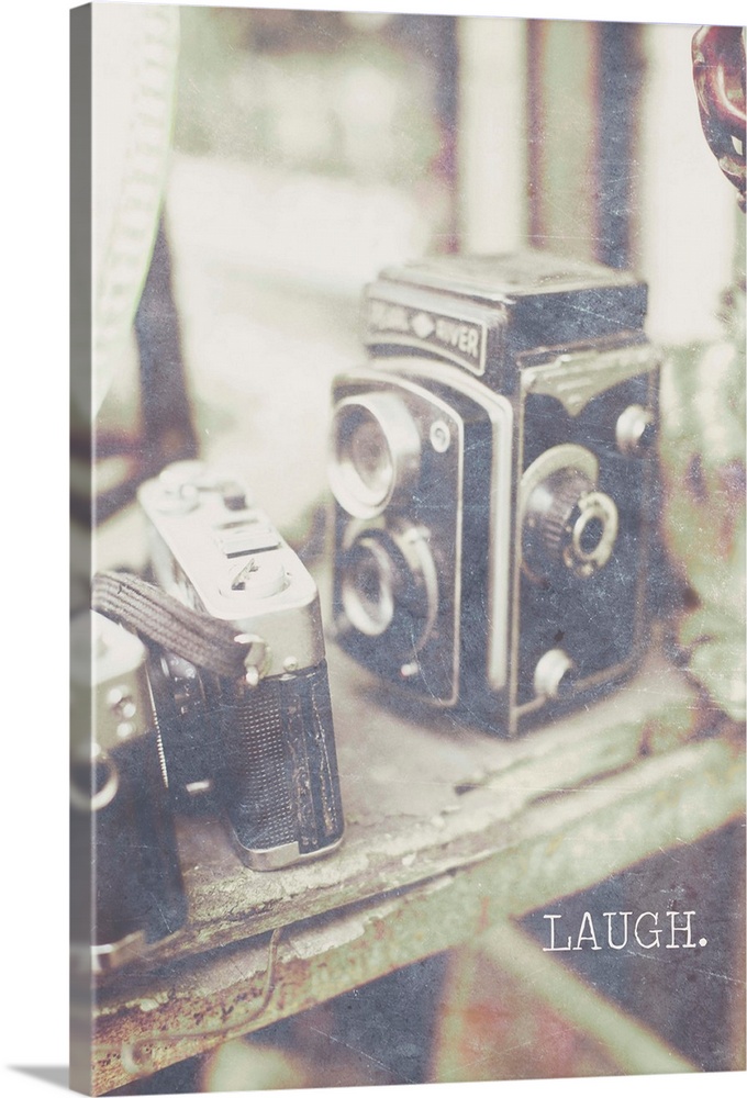 Vintage style photograph of old cameras with "Laugh" written in all caps at the bottom.