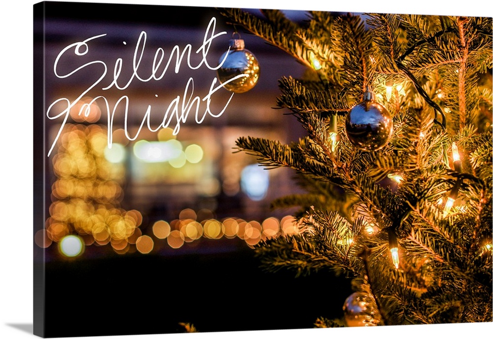 "Silent Night" written in white on a close-up photograph of a decorated Christmas tree.