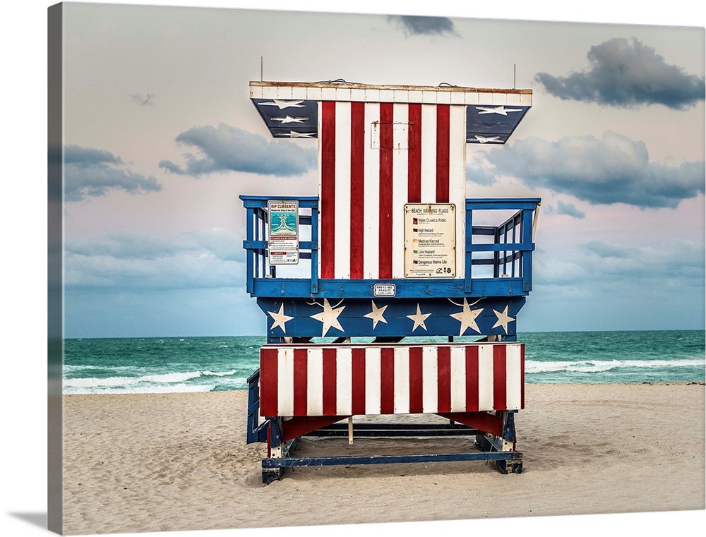 Photograph of a lifeguard tower with an American flag design on the beach.