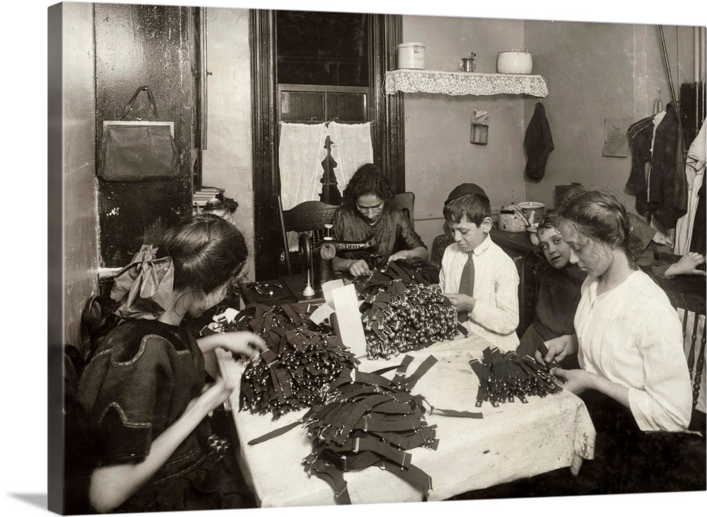 A Jewish family making garters in the kitchen of their tenement home in New York City, New York. Photograph by Lewis Wicke...