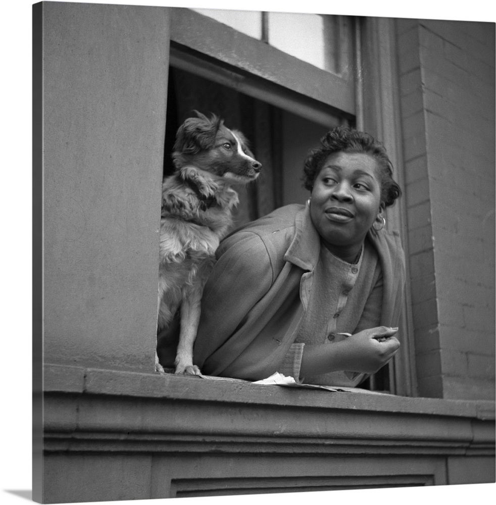 A woman and her dog in the window of their apartment in Harlem, New York City. Photograph by Gordon Parks, May 1943.