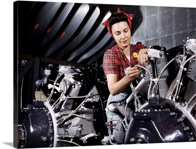 A woman working on an airplane motor at the North American Aviation plant, CA, 1942