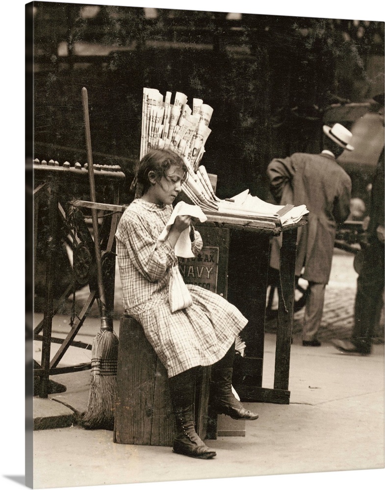 A young newsgirl seated on a crate while tending to the newspaper stand on the Lower East Side of Manhattan, New York. Pho...