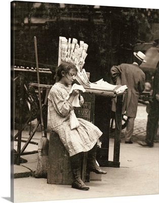 A young newsgirl seated on a crate while tending to the newspaper stand Manhattan, 1910