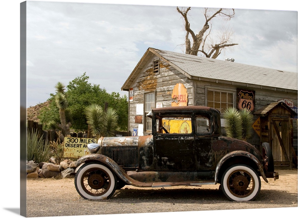 An old rusted automobile in front of the Hackberry General Store along Route 66 in Hackberry, Arizona. Photograph by Carol...