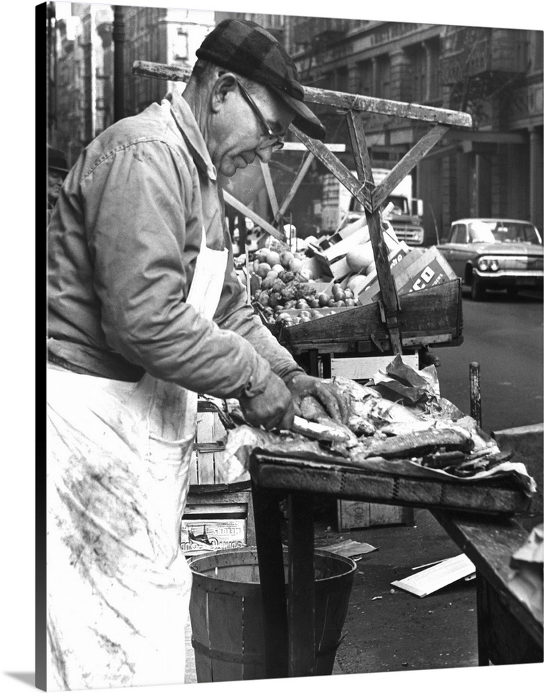 Charles Catalano cleaning fish at his pushcart on Hester Street and Mott Street in New York City. Photograph by Phyllis Tw...