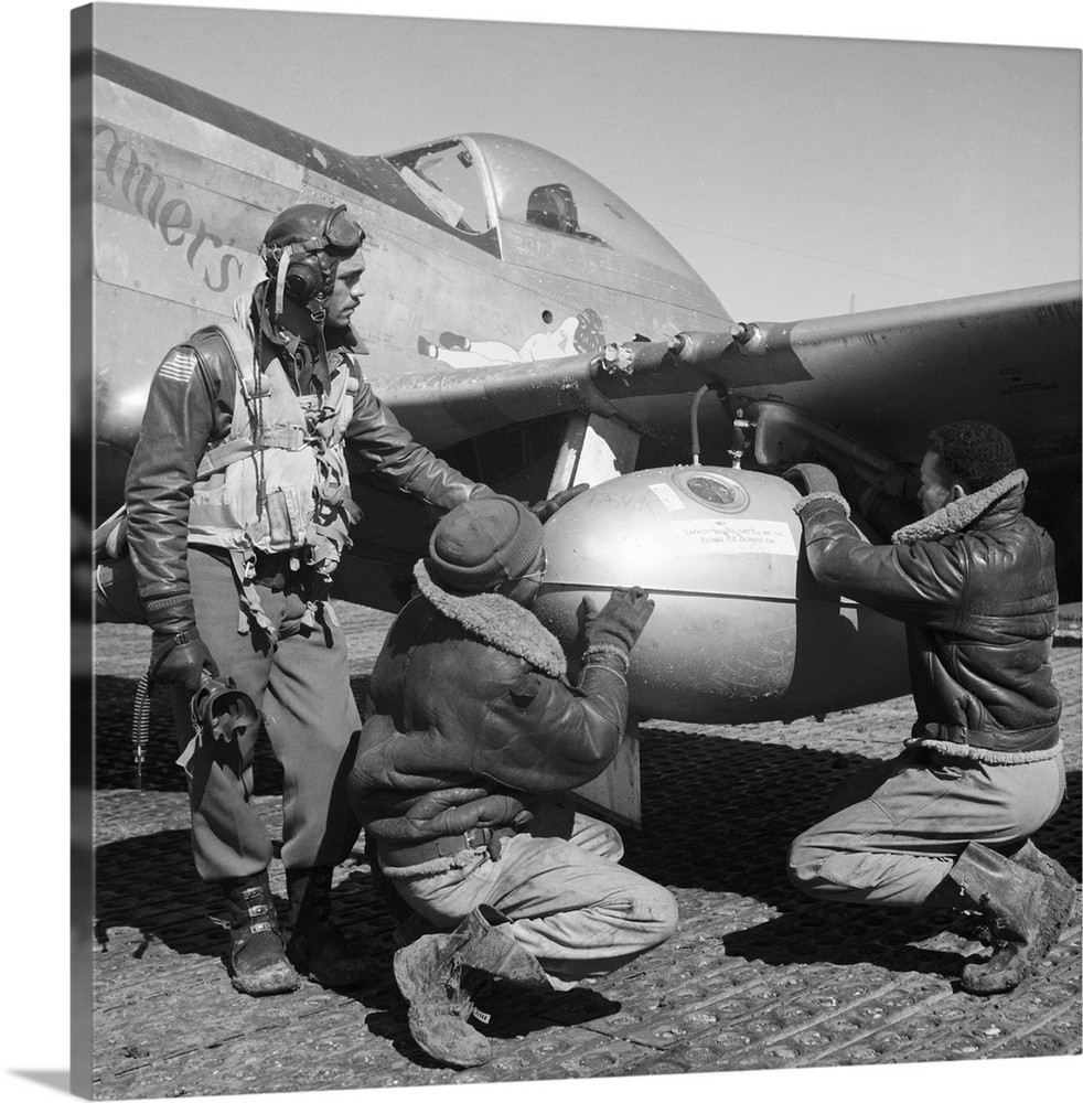 Edward Gleed and two other Tuskegee Airmen adjust an external 75 gallon drop tank on the wing of a P-5