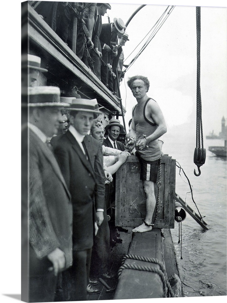 American magician. A shackled Houdini about to be padlocked into a packing case and lowered into New York harbor, 1914.