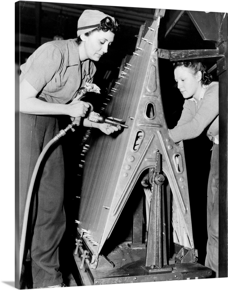 Two women riveting a piece of machinery at an American bomber plant during World War II.