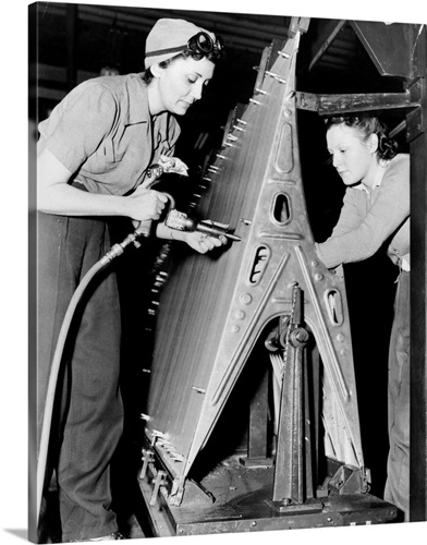 Two women riveting a piece of machinery at an American bomber plant ...