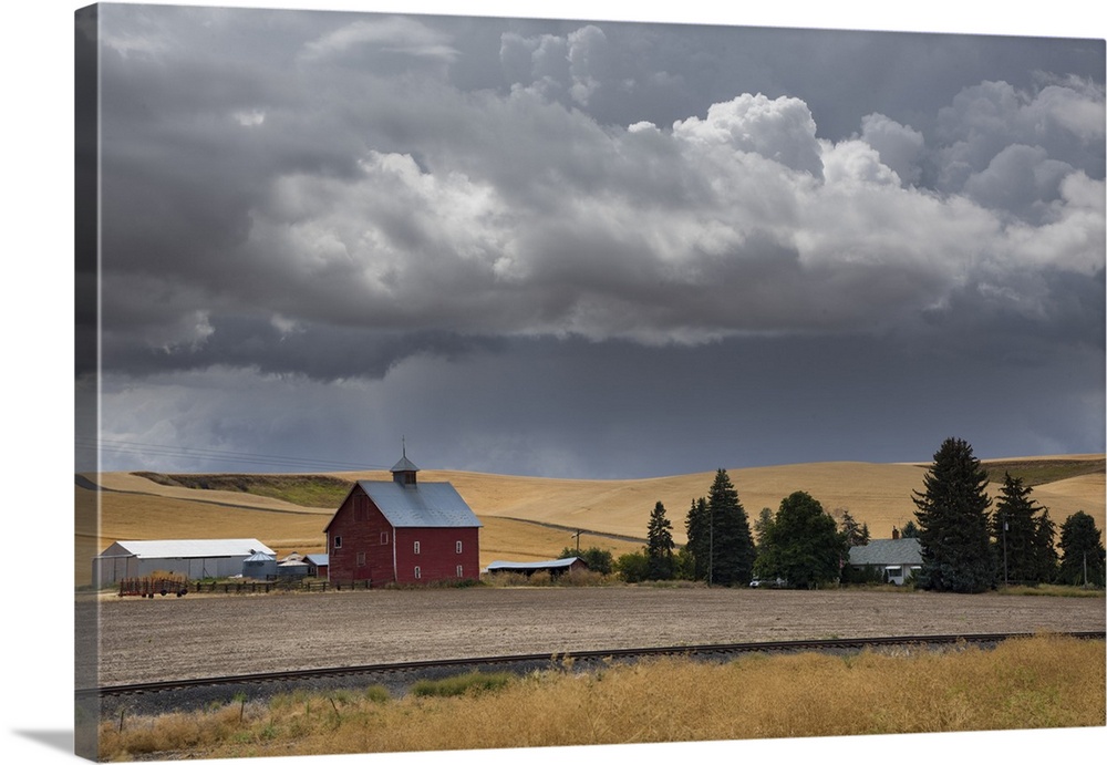 Dark storm clouds over a red barn on a farm in Palouse, Washington.