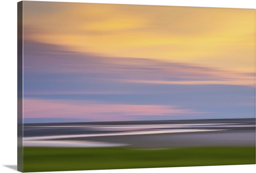 Blurred image of the Atlantic coast at sunset, with a pastel cloudy sky.