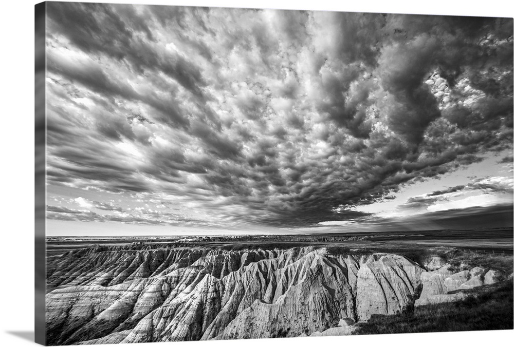 Black and white photo of striking clouds over rock formations in the South Dakota Badlands.