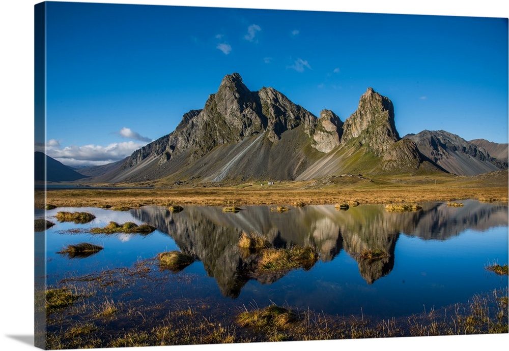 Rugged mountains in Iceland, reflected in the clear lake below.