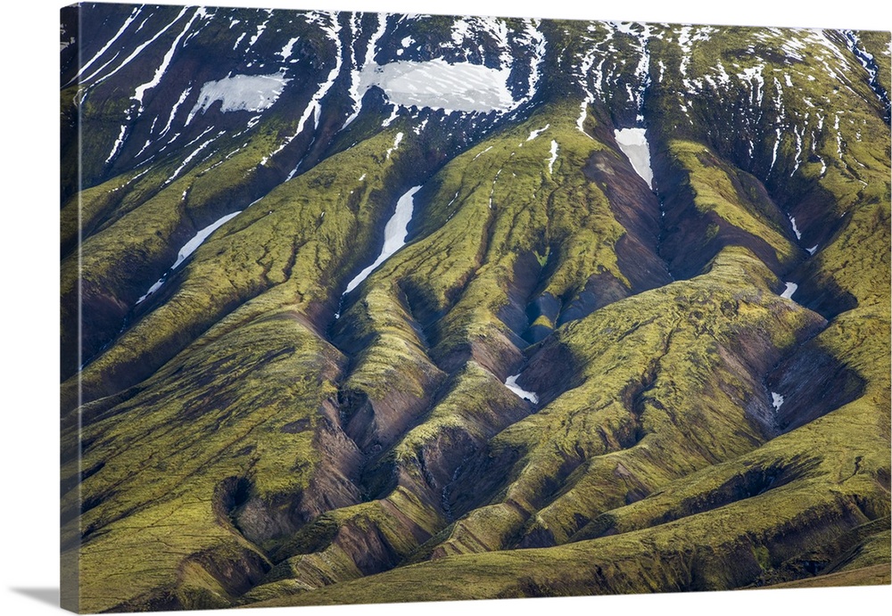 Deep rifts in the mountain landscape formed by years of glacial erosion, seen in an aerial view of Iceland.