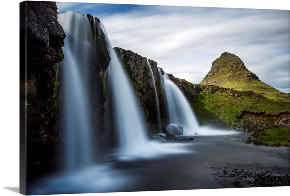 Waterfalls in Iceland with verdant Mount Kirkjufell in the distance.