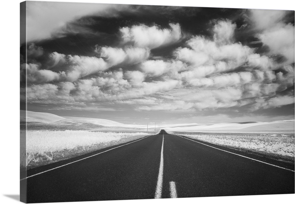Infrared image of a road running through Palouse, Washington, with large clouds in the sky above.
