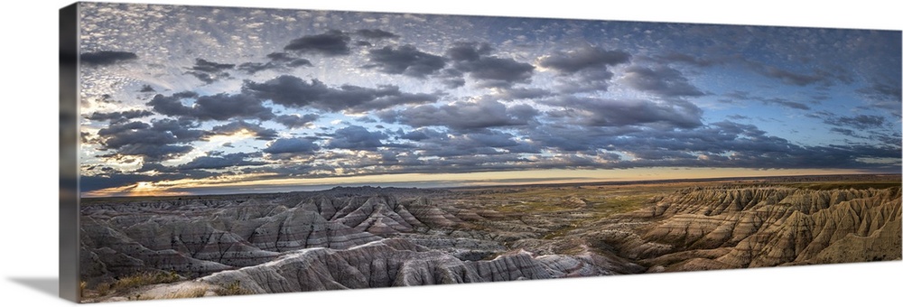 Panoramic view of stunning clouds at sunset over the hilly terrain of the South Dakota Badlands.