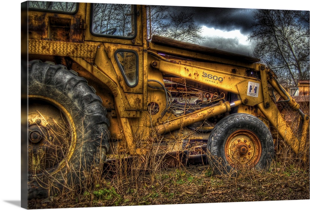 A yellow rusty digger in a field