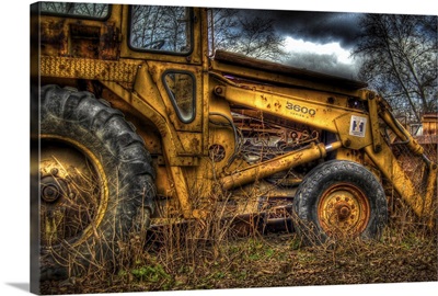 A yellow rusty digger in a field