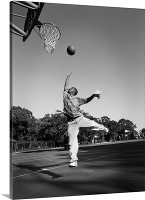A young boy gets air while playing basketball at his school