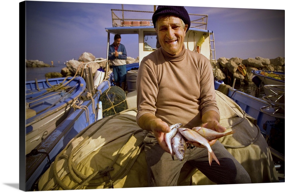 An elderly Italian fisherman shows some of the fish he caught.