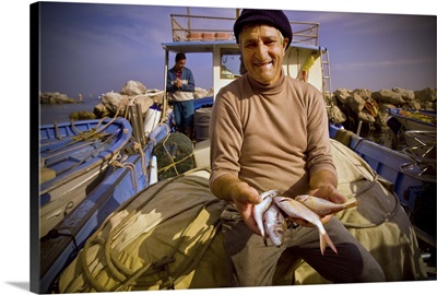 An elderly Italian fisherman shows some of the fish he caught