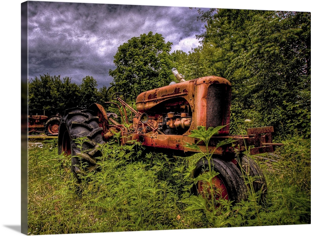 An old red 1950's tractor left to decay in a field