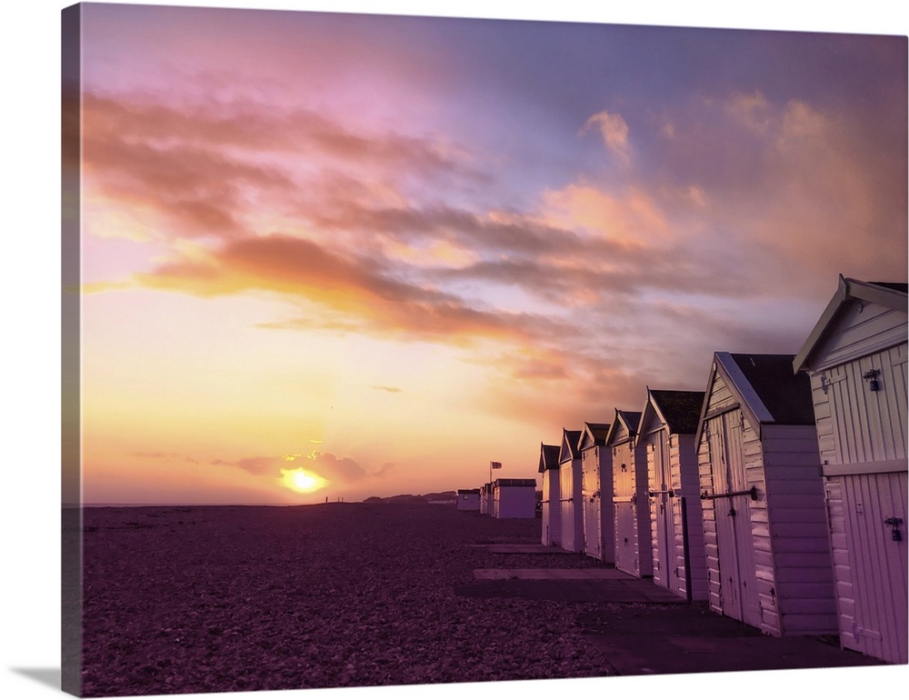 The sun setting over a Sussex beach with a purple sky.