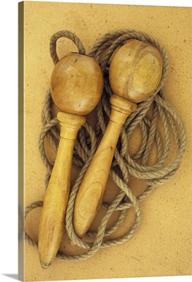 Close up of traditional skipping rope with wooden handles lying on antique paper II