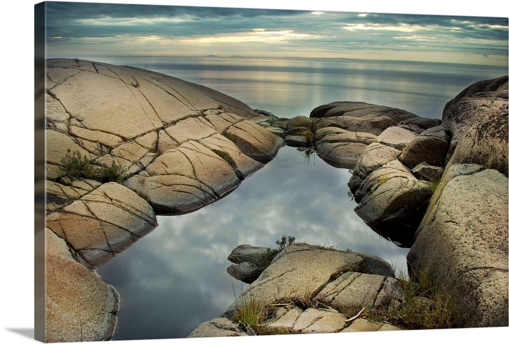 A rocky shore with calm sea and rock pool
