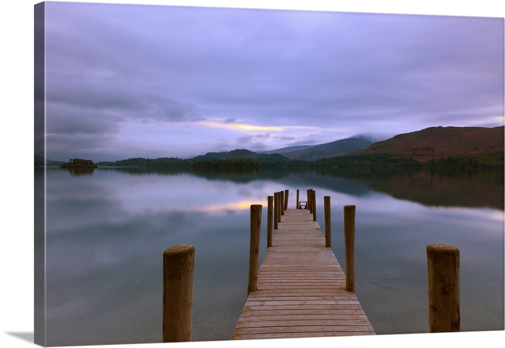 Jetty at twilight in the Lake District looking across still water with reflections