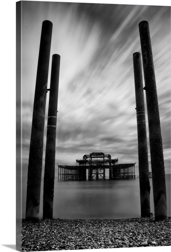 Burnt out remains of the east pier in Brighton in East Sussex, England with long exposure