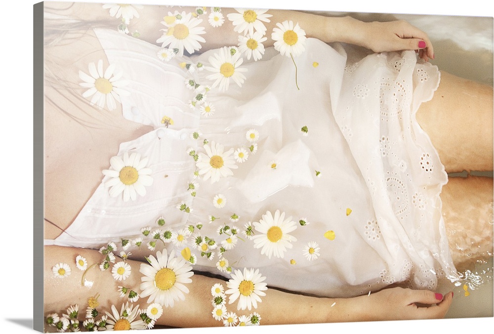 Girl wearing white dress with daisies floating on water surface.