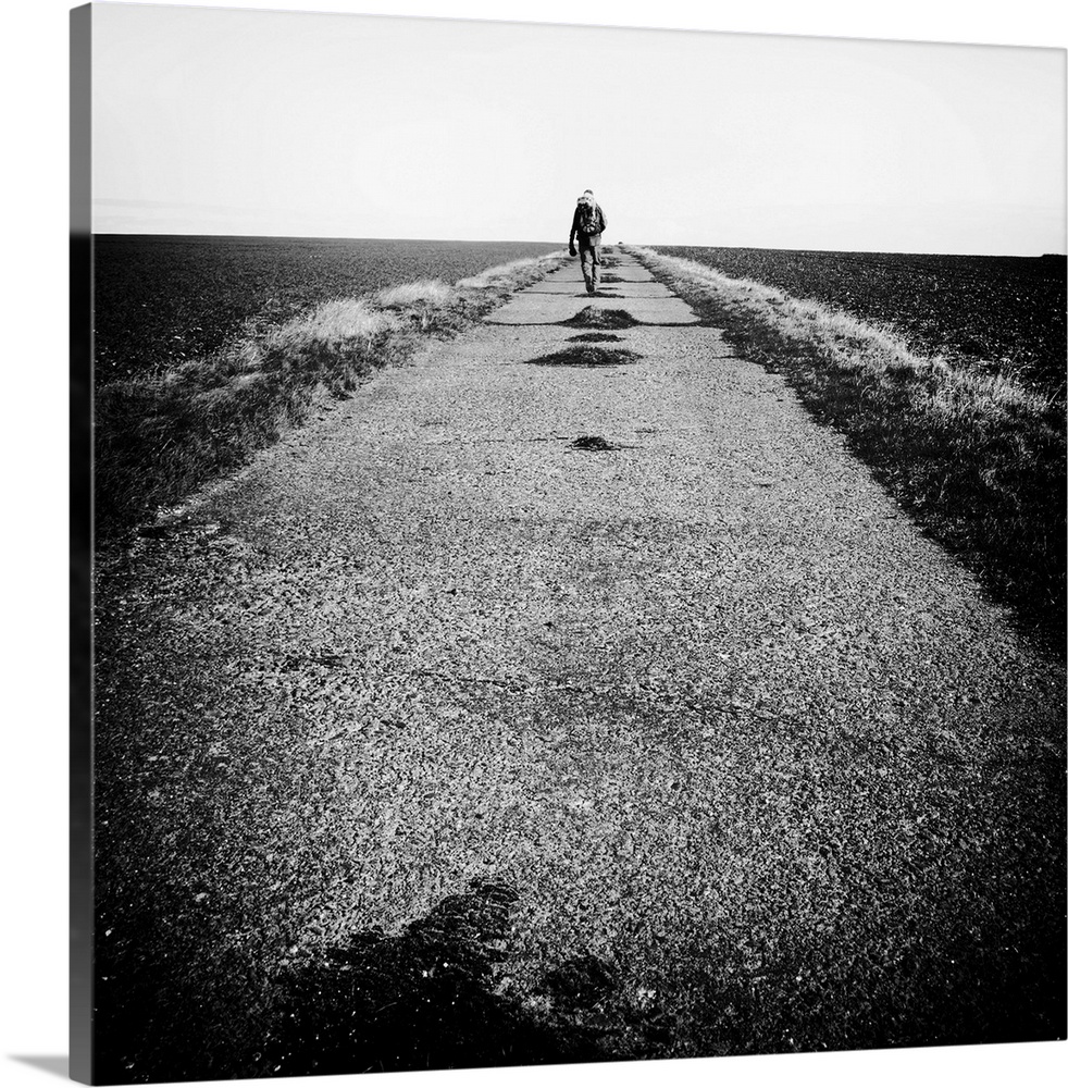 Lone figure on road, hiking with backpack